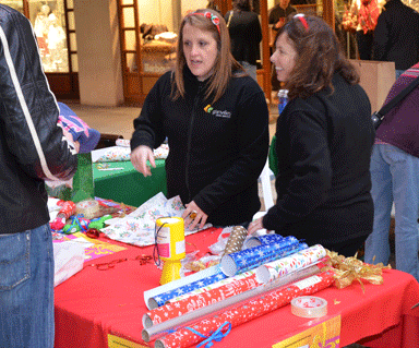 Two participants in raising money for Brain Tumour Research stood around a fundraising table